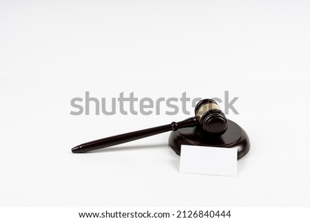 Judge, wooden gavel on the brown wooden background with white, blank business cards. Mockup with copy space