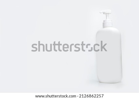Healthcare, medical and personal hygiene treatment concept. Closeup of blank plastic bottle of nasal spray with selective focus isolated on abstract blurred white background. Runny nose. Snuffle.