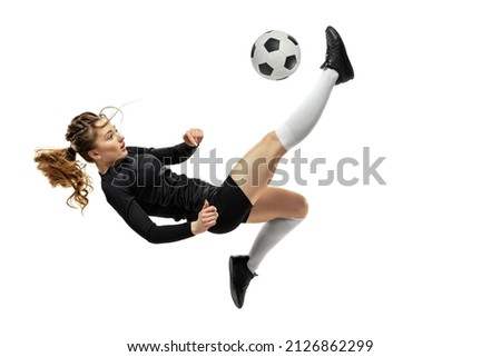 Jumping. One sportive girl, female soccer player training with football ball isolated on white studio background. Concept of sport, fitness. Young sportive girl in motion. Copy space for ad