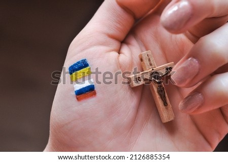 Orthodox Christ and drawned Russian and Ukrainian flags in hand. translation from Russian :Jesus Christ  Royalty-Free Stock Photo #2126885354