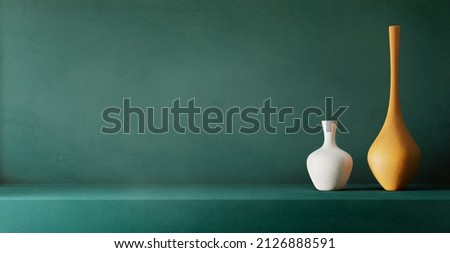 Minimal interion design with ceramic vases on teal plaster texture wall. Product placement showroom with neutral home decor. Home architecture background with neutral aesthetic.  Royalty-Free Stock Photo #2126888591