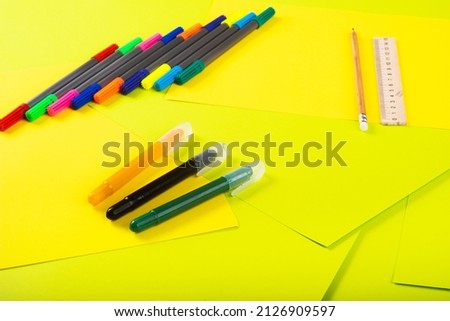 Set of color papers, scissors, ruler, felt-tip pens and pencil for creative work on multi-colored background. Top view. Flatlay. Paper craft projects.