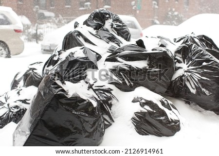 Garbage bags under snow on the street at New York city