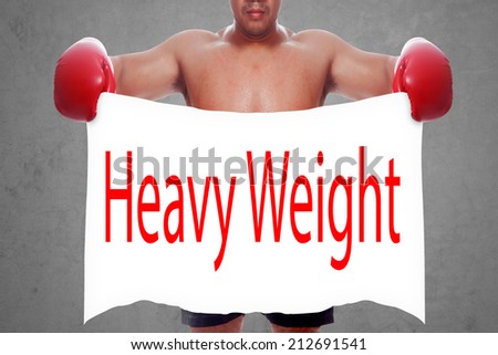fight and competition sign with an red boxing glove holding a white banner and word heavy weight a business symbol of competitive sales or boxing specials day  