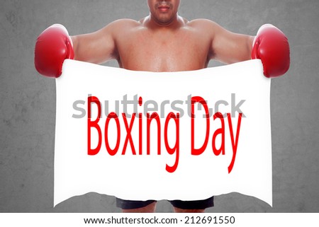 fight and competition sign with an red boxing glove holding a white banner and word boxing day a business symbol of competitive sales or boxing specials day  