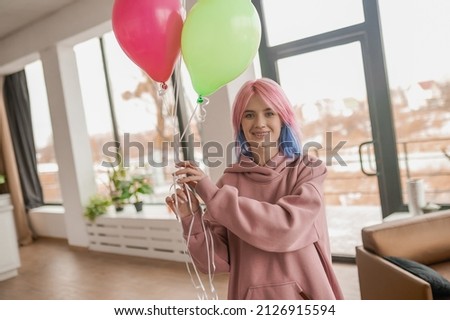 A happy smiling young girl with a bunch of balloons