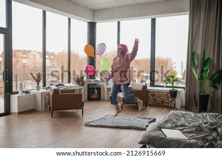 A happy smiling young girl with a bunch of balloons