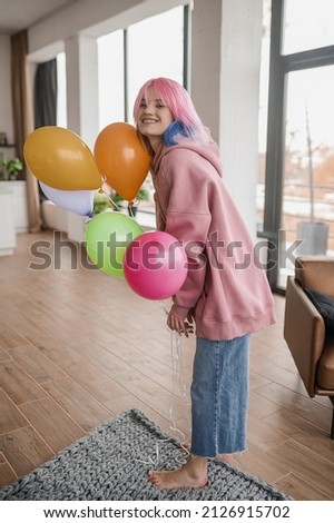A girl with bright balloons feeling happy and joyful