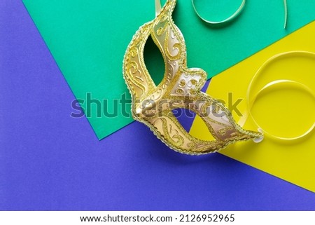Golden carnaval mask on green yellow and purple background straight lines