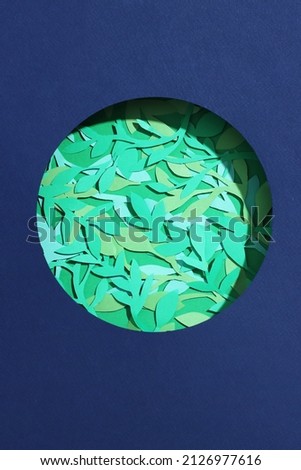Green leaves on paper planet in center. Concept earth day, save the planet card. High quality photo