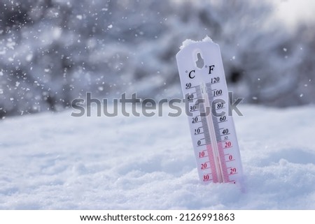 Low temperature thermometer in the snow in Celsius or Fahrenheit.