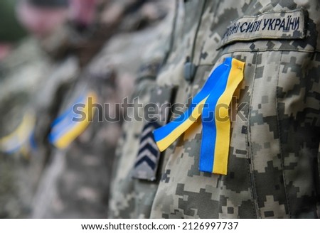 Yellow and blue ribbon (colors of Ukraine) attached to the chest of the Ukrainian Army (inscription in Ukrainian "Armed Forces of Ukraine") Royalty-Free Stock Photo #2126997737
