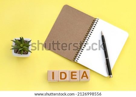 Notepad and pen on the background. Wooden cubes with word idea.  Notebook for ideas message, notes, list and inspiration. Concept  idea, start. Top view