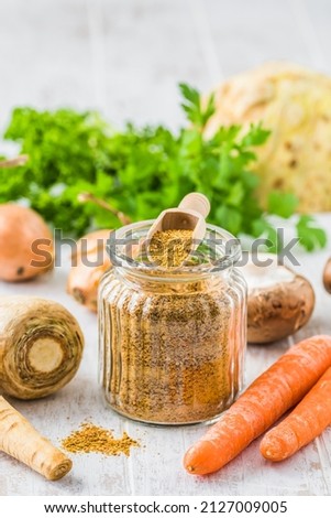 Homemade vegetable broth powder, organic vegetable stock, with raw vegetables on white wooden background, vertical with copy space