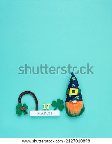 Cute irish gnome, horseshoe for good luck, decorative clover leaves, 17 march date calendar on green background. Saint Patrick day, traditional irish holiday concept. close up. flat lay