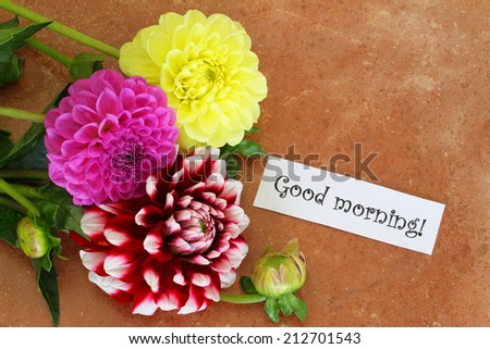Good morning card with colorful dahlias on terracotta surface with copy space 