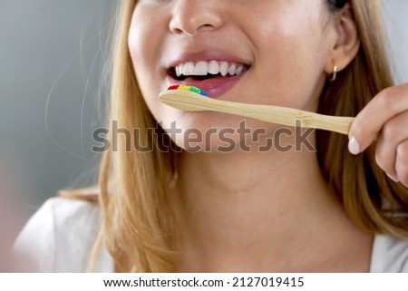 Close up of girl mouth with eco friendly bamboo toothbrush. Happy woman brushing teeth with wooden bamboo toothbrush. Royalty-Free Stock Photo #2127019415