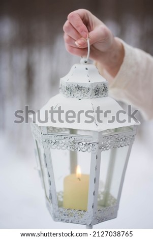 girl holding a white lantern with a candle