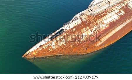 Aerial top down photo of capsized abandoned passenger ship left to rust near shore Royalty-Free Stock Photo #2127039179
