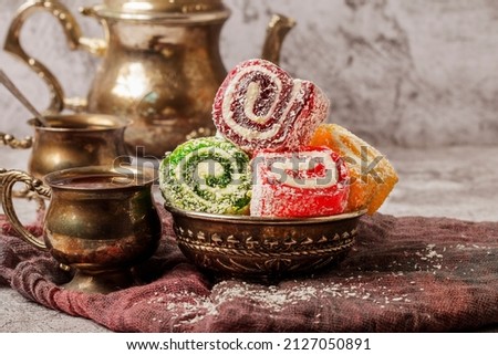 Traditional Turkish delight with Turkish tea on gray background. Ramadan Kareem celebration concept. Fragrant Turkish tea and Turkish sweets in national dishes. Royalty-Free Stock Photo #2127050891