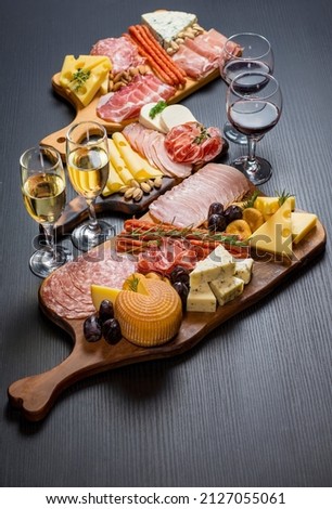 Wine and charcuterie and cheese board with a place for text. Prosciutto di Parma ham, blue cheese. Italian appetizers or antipasto set with gourmet food on table top view. Mixed delicatessen Royalty-Free Stock Photo #2127055061