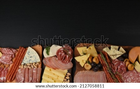 Mixed delicatessen with charcuterie and cheese board with a place for text.  Space for banner, logo, copy space. Italian appetizers or antipasto set with gourmet food on table flat lay  Royalty-Free Stock Photo #2127058811