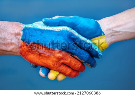 Handshake of hands with the flag of Ukraine and the flag of Russia. Truce. Arrangement.