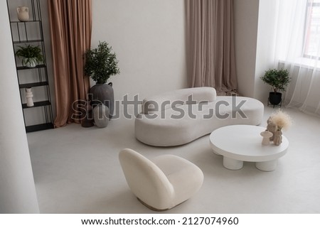 Part of large cozy and light living-room with white round table with handmade vases, comfortable sofa and armchair in apartment Royalty-Free Stock Photo #2127074960