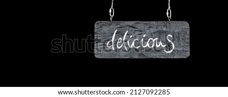 Hanging wooden restaurant sign isolated black banner. Delicious word text with copy space on black background