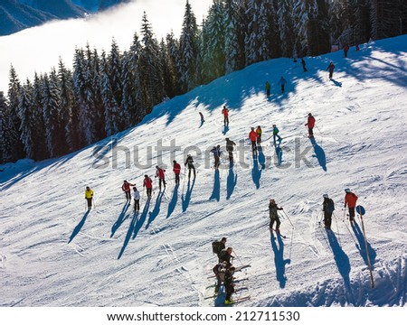 Mountain ski resort. Picture with skiers group of people, trees and fog 