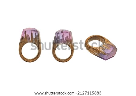 Photo of a wooden female ring on a white background. Epoxy resin is often used for decor and decorations. Eco-friendly material to create beautiful things. Bright unusual gift for a girl.