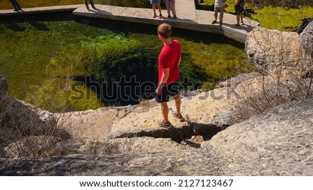 Hiker at Jacob’s Well in Wimberley, TX Royalty-Free Stock Photo #2127123467