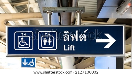 Sign in English and Thai languages on a train platform on the Bangkok BTS Skytrain