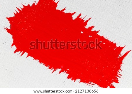 thick red acrylic paint applied in an uneven patch on a flat surface 