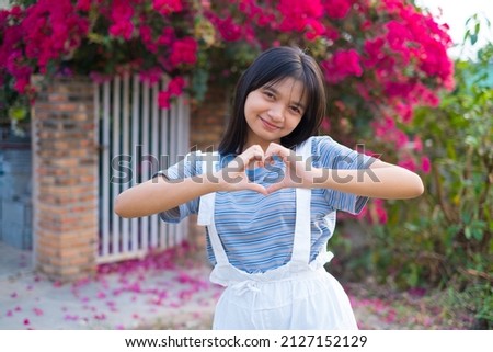 Portrait Young Asian girl outdoor, beautiful flower background.