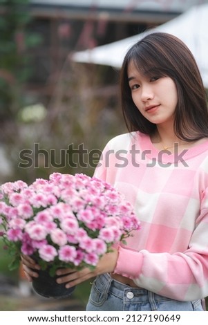 young happy woman person smiling with pink flower blooming, pretty cute girl portrait in summer with nature flower plant in pink color and colorful natural outdoor