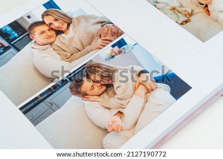 a book with photos of couple at home on a white background. Photobook is gift. professional photographer and designer. printing of photos and journals in photo laboratory