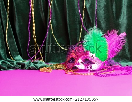 Festive carnival mask for Mardi Gras festival, green velvet curtain purple background