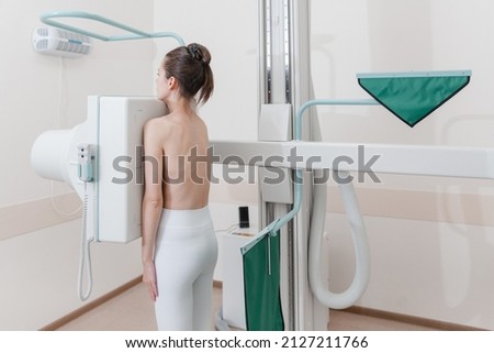 Hospital Radiology Room. Xray machine for fluorography. Woman patient scanning chest, heart or lungs in clinic office. Adult female undergoes healthcare exam. Medical X-ray equipment for radiography.