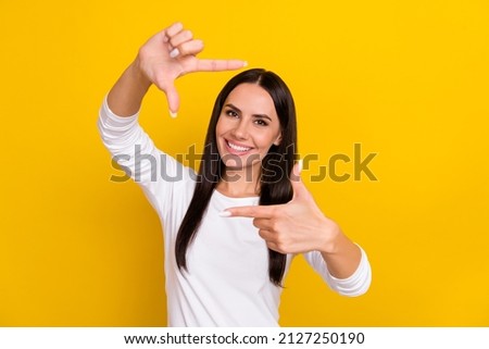Photo of young lovely woman show hands photo shooting symbol trip isolated over yellow color background
