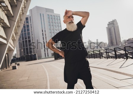 Photo of sportive tired retired man black sportswear finishing cardio training outside urban city street