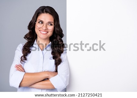 Photo of successful dreamy lady crossed hands look empty space wear glasses blue shirt isolated grey color background