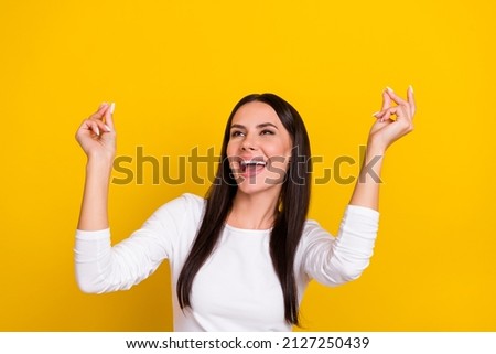 Photo of young cheerful girl good mood chill club look empty space isolated over yellow color background
