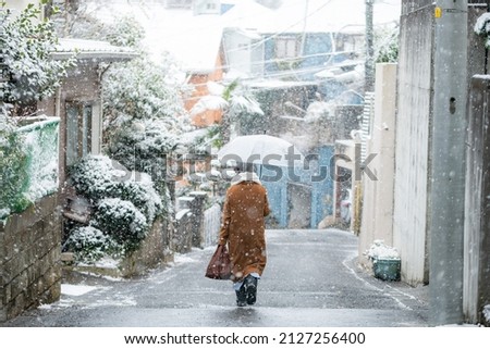 Woman holding umbrella outdoors in snowy winter
