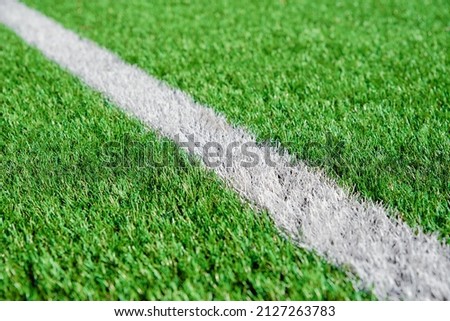 Part of football or soccer field close up, Artifical green grass with white border lines, Astroturf at stadium for spart games Royalty-Free Stock Photo #2127263783
