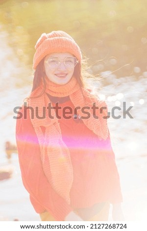 autumn portrait of a girl in glasses in an orange hat and sweater