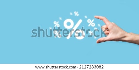 Male hand holding interest rate percent icon on blue background. Interest rate financial and mortgage rates concept.Banner with copy space.