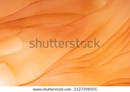 Abstract fluid art painting in alcohol ink technique. Flowing translucent paint warm hues. Background similar to the landscape of movement sands. Designed for wall art, postcard or poster, cover. Royalty-Free Stock Photo #2127298505