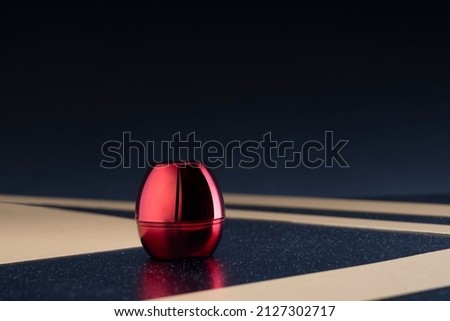 Bright glossy red box on a striped base with a metallic reflection Royalty-Free Stock Photo #2127302717