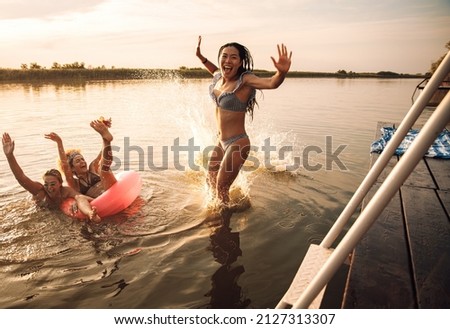 Group of female friends enjoying a summer day swimming at the lake.